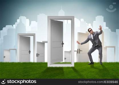 Confused businessman in front of doors