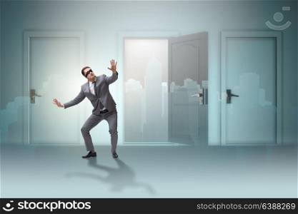 Confused businessman in front of doors