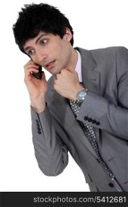 confused businessman talking on his cell