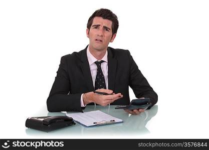 Confused businessman with a calculator