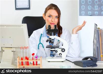 Confused doctor woman working with microscope in laboratory&#xA;