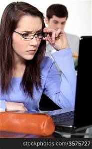 Confused female student looking at laptop screen