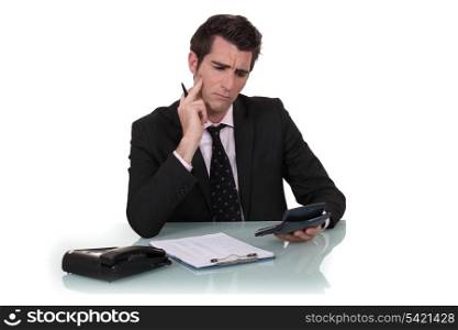 Confused man holding calculator
