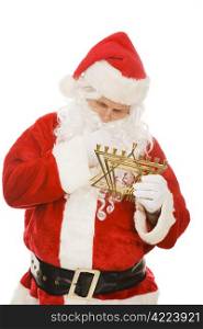 Confused Santa Claus looking at a Chanukah menorah. Isolated on white.
