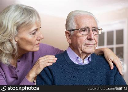 Confused Senior Man Suffering With Depression And Dementia Being Comforted By Wife