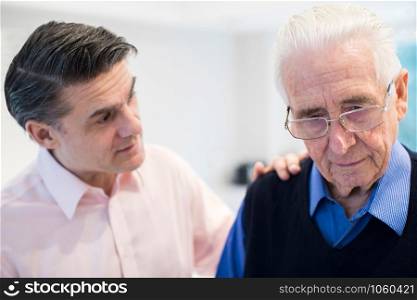 Confused Senior Man With Adult Son At Home