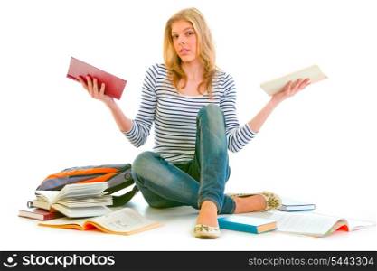 Confused teenager sitting on floor among schoolbooks isolated on white &#xA;