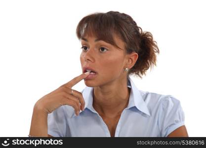 Confused woman holding finger to mouth
