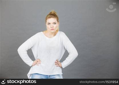 Confused young blonde woman looking suspicious. Confusion face expressions concept. Studio shot on grey background.. Confused young blonde woman looking suspicious