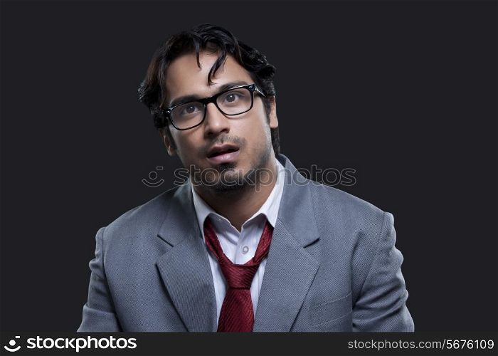 Confused young businessman over black background