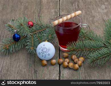 coniferous branch with Christmas tree decorations, tea and nutlets, the subject Christmas and New Year