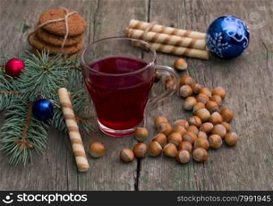 coniferous branch with Christmas tree decorations, tea, sweets and nutlets, the subject Christmas and New Year