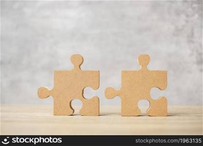 connecting couple puzzle piece, wood jigsaw on table. Business solutions, mission, success, goals and strategy concepts