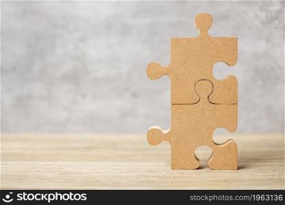 connecting couple puzzle piece, wood jigsaw on table. Business solutions, mission, success, goals and strategy concepts