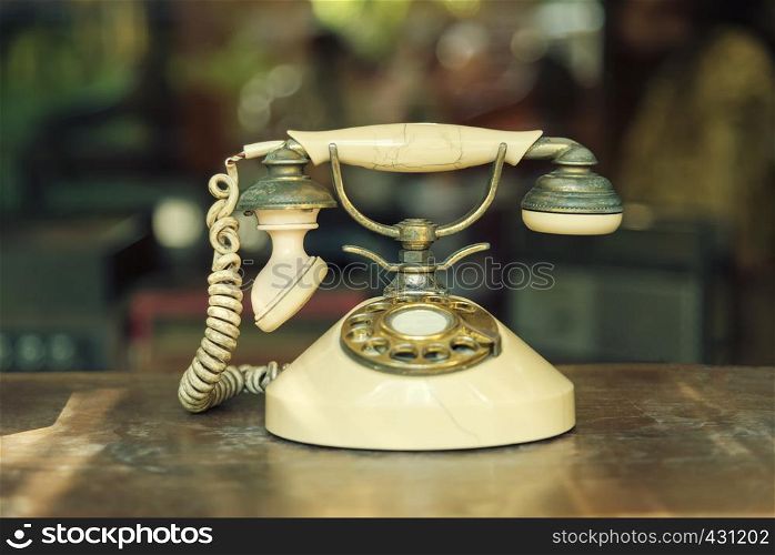 Connection technology concept. Old telephone on wood table with blurred background. Vintage and retro backdrop. Picture for add text message. Backdrop for design art work.