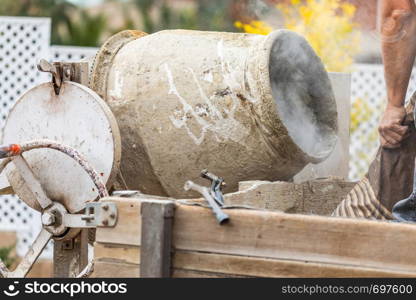 Construciton Worker Mixing Cement At Construction Site.