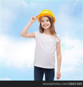 construction and people concept - smiling little girl in protective helmet looking up