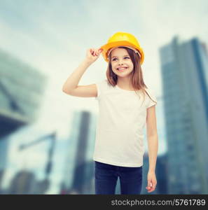 construction and people concept - smiling little girl in protective helmet looking up