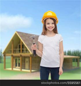 construction and people concept - smiling little girl in protective helmet with hammer