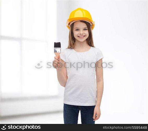 construction and people concept - smiling little girl in protective helmet with paint brush