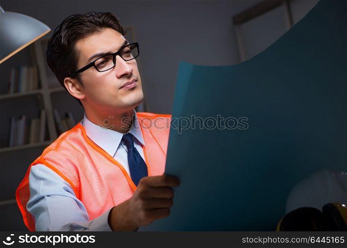 Construction architect working on drawings late at night