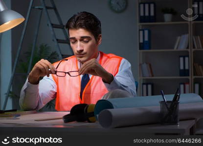 Construction architect working on drawings late at night