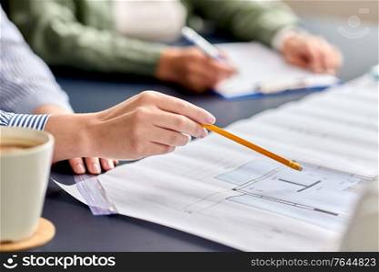 construction business, architecture and team work concept - close up of architects with blueprint, gadgets and papers working at office table. business team with blueprint working at office
