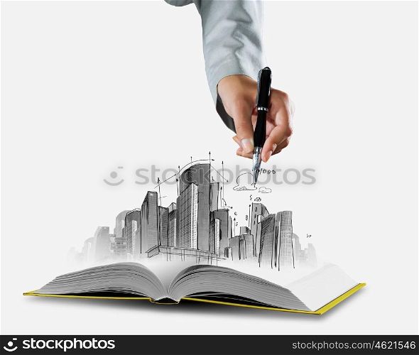 Construction business. Opened book and hand drawing building sketches