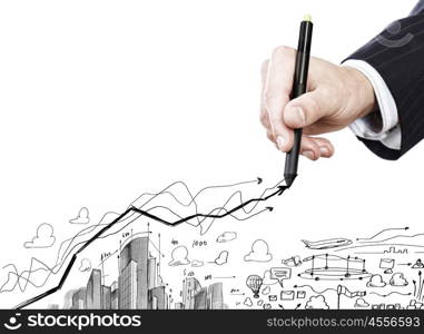 Construction concept. Close up of businessman hand drawing sketches of buildings