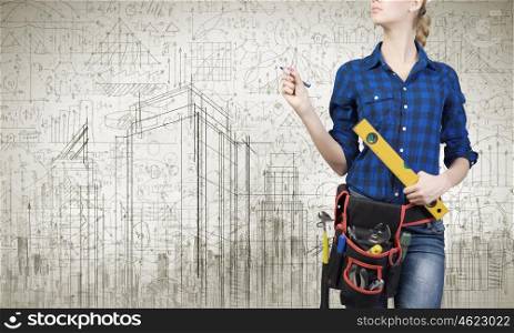 Construction concept. Close up of woman mechanic with ruler in hand against city background