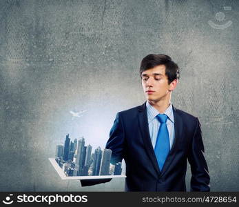 Construction concept. Handsome businessman holding model of modern city