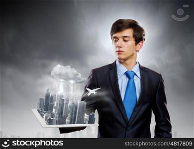 Construction concept. Handsome businessman holding model of modern city