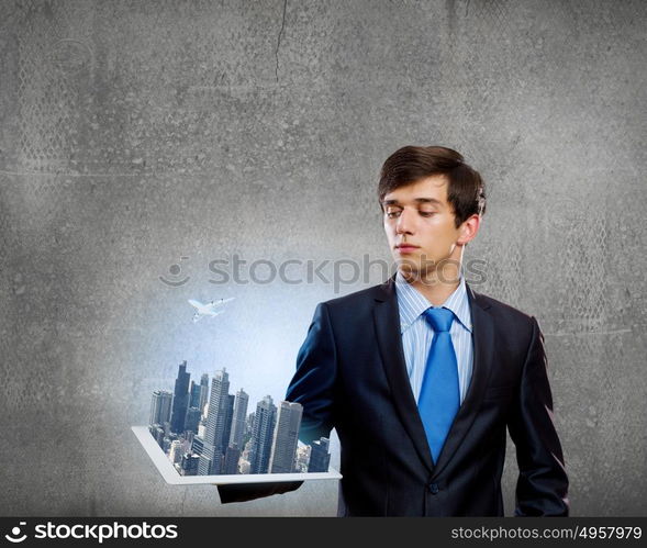 Construction concept. Handsome businessman holding model of modern city