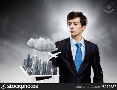 Construction concept. Handsome businessman holding model of modern city