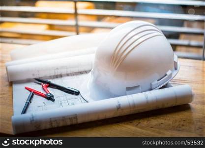 construction concept image helmet rolled blueprints on wooden boards in retro style.