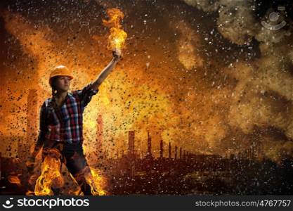 Construction concept. Image of woman in hardhat with torch in fire flames