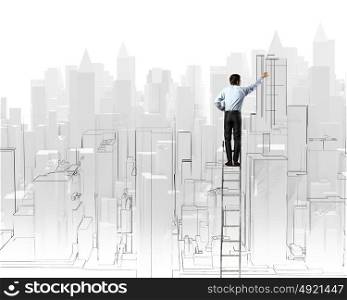 Construction concept. Rear view of businessman standing on ladder and drawing project