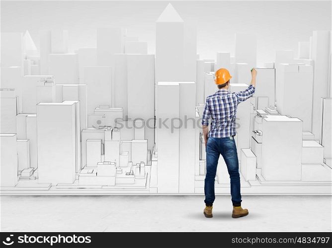 Construction concept. Rear view of engineer drawing project of business district