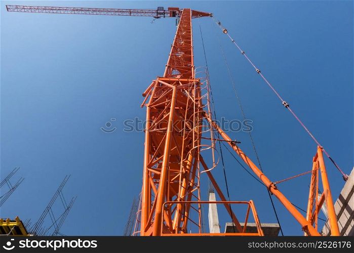 construction crane and unfinished building on sky background. bottom view. construction crane and building