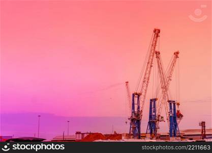 construction cranes and building silhouettes on sunset. construction cranes and building silhouettes