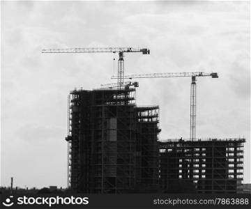 Construction Cranes and Buildings Silhouetted against sky in Black and White