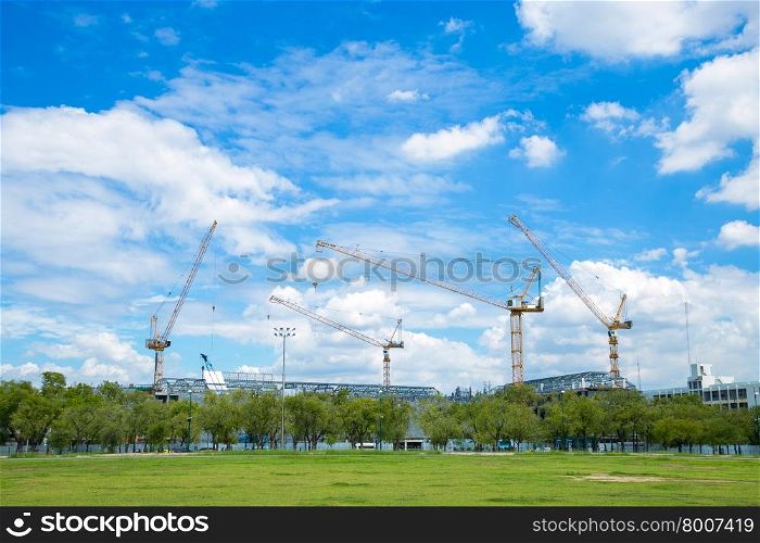 Construction cranes in construction area Large building construction The sky is clearing up.