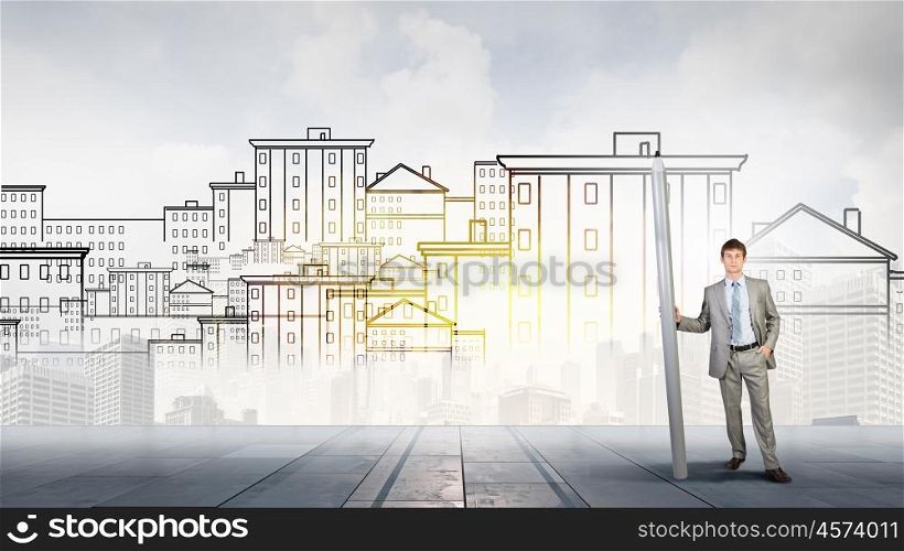 Construction designer. Young man architecture designer with huge pencil