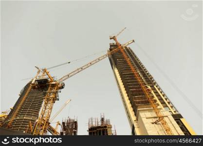 construction, development, architecture, industry and engineering concept - building of skyscraper in Dubai city