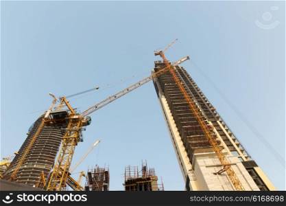 construction, development, architecture, industry and engineering concept - building of skyscraper in Dubai city