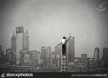 Construction development project. Rear view of businessman standing on ladder and drawing buildings