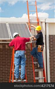 Construction electricians installing solar panels on the side of a building.