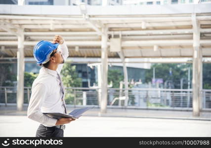 Construction engineer in Safety Suit Trust Team Holding White Yellow Safety hard hat Security Equipment on Construction Site. Hardhat Protect Head for Civil Construction Engineer. Engineering Concept