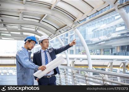 Construction engineer in Safety Suit Trust Team Holding White Yellow Safety hard hat Security Equipment on Construction Site. Hardhat Protect Head for Civil Construction Engineer. Engineering Concept