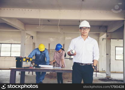 Construction engineer teamwork Safety Suit Trust Team Holding White Yellow Safety hard hat Security Equipment on Construction Site. Hardhat Protect Head for Civil Construction Engineer Concept